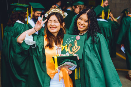 two girls in green graduation robes and caps