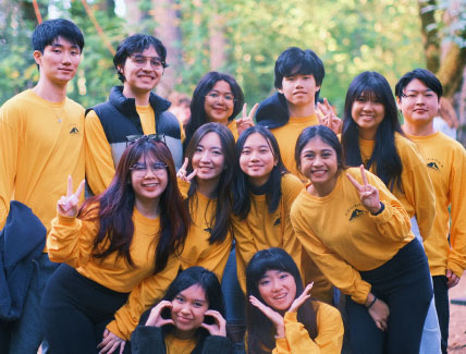 large group of smiling students in gold shirts