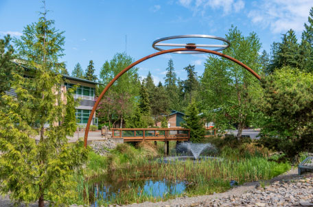 beautiful trees and large metal sculpture near buildings