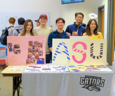 group of young people smiling and holding signs