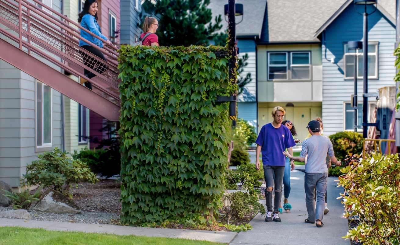 housing area with beautiful plants and happy students